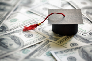 graduation cap sitting on money