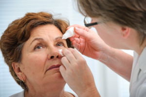 Senior woman applying eye drops