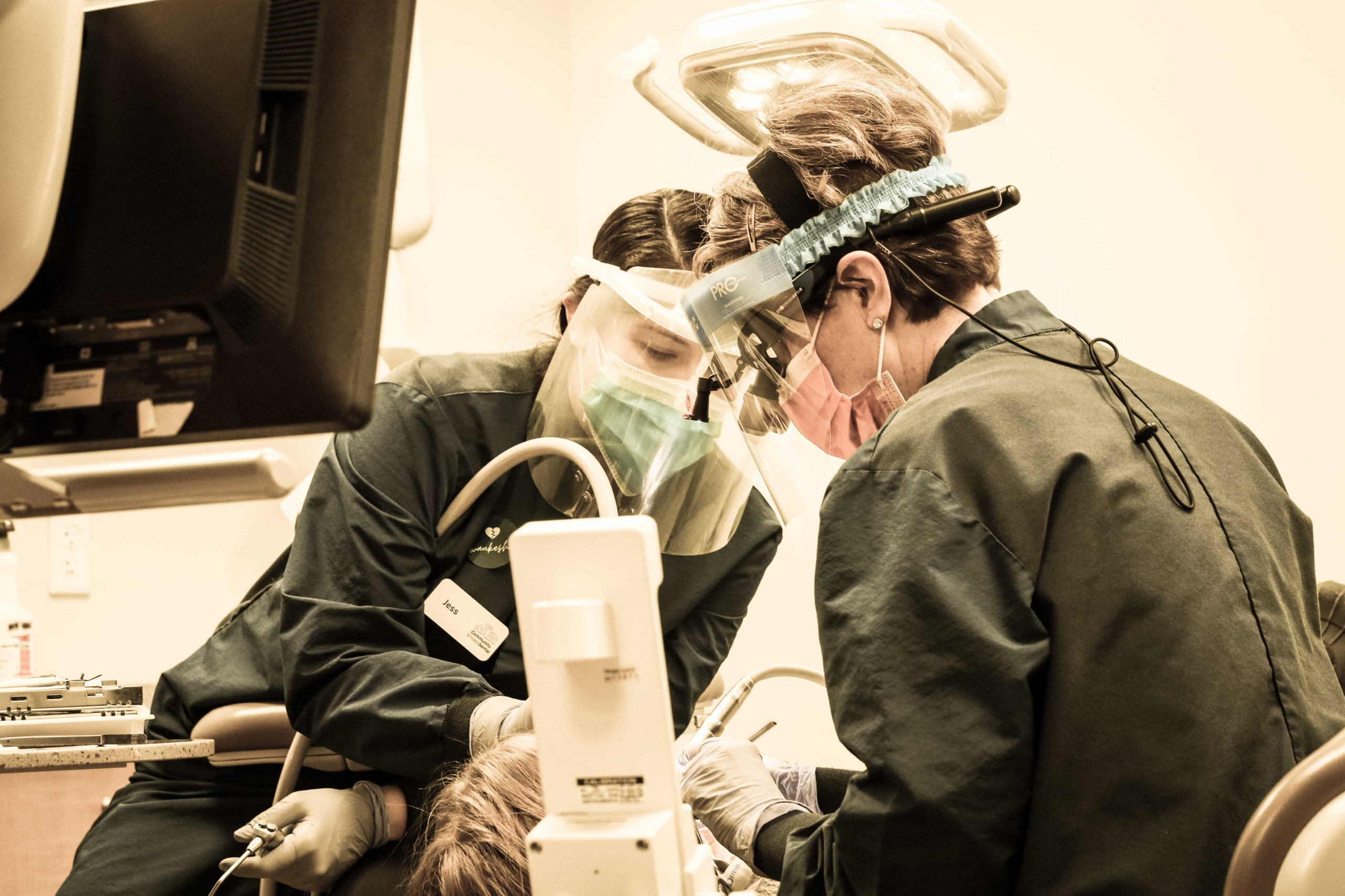 Dentist and hygienist providing a cleaning to a child