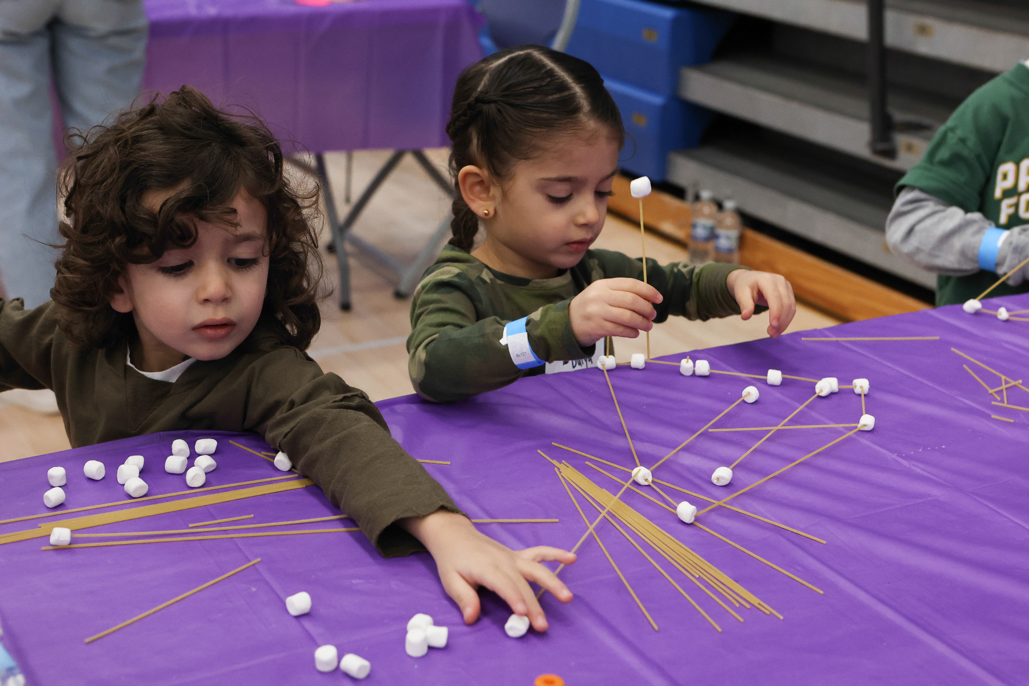 kids participating in experiment with spaghetti and marshmallows