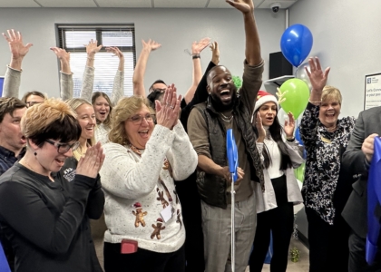 people cheer after ribbon cutting for clinic