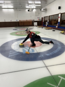 man delivers stone in curling practice